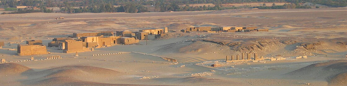 Overview of the excavated settlement with temples, monuments, and archaeological structures emerging from the desert.