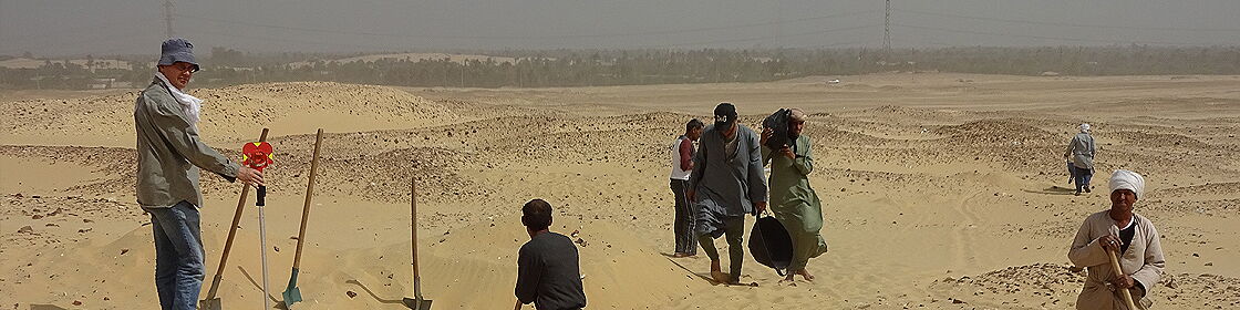 Excavation team and local workers conducting fieldwork at an archaeological site.