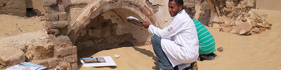 Conservation specialist documenting architectural remains at an archaeological site